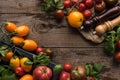 Top view of tomatoes and spinach in box near pepper mill and salt mill on piece of fabric on wooden surface. Royalty Free Stock Photo