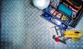 Top view of tools box and helmet on checkered plate background in workshop. Service tools set. Home building and electrical tools. Royalty Free Stock Photo