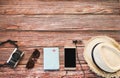 Top view of tourist accessories  on wooden table background camera ,hat ,passport, mobile phone,sunglasses Royalty Free Stock Photo