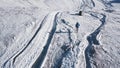Top view of tourist walking in snowy mountains. Clip. Climber walks along snowy slopes of massive mountain on sunny day
