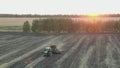 Aerial Top view, tractor plants spring wheat at sunset, sowing winter crops, Autumn, Russia