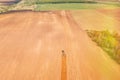 Top View Tractor Plowing Field In Spring Season. Beginning Of Agricultural Spring Season. Cultivator Pulled By A Tractor