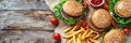 Top view of traditional burger and french fries on wooden table with space for text Royalty Free Stock Photo