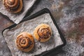 Top view traditional fresh sweet homemade cinnamon rolls with chocolate cream on a baking sheet. Copy space. Scandinavian cuisine