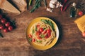 top view of traditional italian pasta with tomatoes and arugula in plate on wooden table Royalty Free Stock Photo