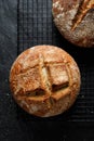 Top view of traditional sourdough artisan loaf of bread on a black background