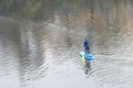 Top view of trained woman standing on the stand-up paddle board and walking on the calm water of river. Royalty Free Stock Photo