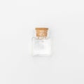 Top view of transparent empty glass jar bottle with closed brown cork cap lids on white background Royalty Free Stock Photo