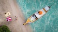 Top view of travel boat, traveller couple, beach and blue sea in summer time