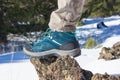 Top view of trekking shoes on the lava stone and snow background, female legs Royalty Free Stock Photo