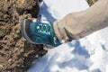 Top view of trekking shoes on the lava stone and snow background, female legs Royalty Free Stock Photo