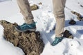 top view of trekking shoes on the lava stone and snow background, female legs Royalty Free Stock Photo