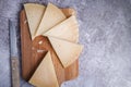 Top view of triangle pieces of cured Manchego cheese with a knife on a wooden food board