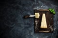 Top view of triangular piece of hard cheese on wooden cutting board