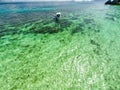 Top view of a tropical island with palm trees and blue clear water. Aerial view of a white sand beach and boats over a coral reef Royalty Free Stock Photo