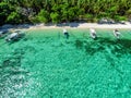 Top view of a tropical island with palm trees and blue clear water. Aerial view of a white sand beach and boats over a coral reef Royalty Free Stock Photo
