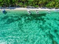 Top view of a tropical island with palm trees and blue clear water. Aerial view of a white sand beach and boats over a coral reef Royalty Free Stock Photo