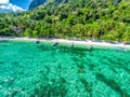 Top view of a tropical island with palm trees and blue clear water. Aerial view of a white sand beach and boats over a coral reef Royalty Free Stock Photo