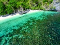 Top view of a tropical island with palm trees and blue clear water. Aerial view of a white sand beach and boats over a coral reef Royalty Free Stock Photo