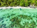 Top view of a tropical island with palm trees and blue clear water. Aerial view of a white sand beach and boats over a coral reef Royalty Free Stock Photo