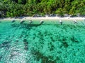 Top view of a tropical island with palm trees and blue clear water. Aerial view of a white sand beach and boats over a coral reef Royalty Free Stock Photo