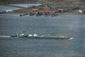 Top view of Tugboat pushing a heavy barge on the river