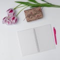 top view of tulips, gift and empty notepad on white background Royalty Free Stock Photo