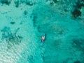 Top view of turquoise ocean water and fisherman on boat, aerial drone shot Royalty Free Stock Photo