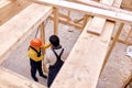 Top view on two architets builders working together, building wooden cottage house. Royalty Free Stock Photo