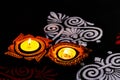 Top view of two beautiful clay lamps with colorful rangolis on black background. diwali concept Royalty Free Stock Photo