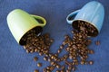 Top view of two colorful mugs full of roasted coffee beans on the table Royalty Free Stock Photo