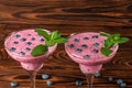 Top view of two colorful smoothie cocktails on a wooden background. Refreshing beverages with juicy blue berries and mint leaves. Royalty Free Stock Photo