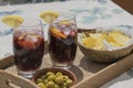 Top view of two crystal glasses filled with red wine and soda with ice cubes and slices of lemon typical spanish on a wooden tray