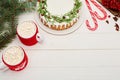 Top view of two cups of cocoa with marshmallows and christmas pie with icing on white wooden table.