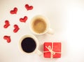 Top view of  two cups of coffee, red  gift box  and six red glitter hearts  on white background. Valentine`s day concept Royalty Free Stock Photo