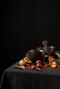 Top view of two cups of tea on table with black tablecloth, nuts and lit black candle for Halloween, Royalty Free Stock Photo