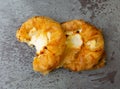 Top view of two delicious cream cheese danishes with one half eaten on a gray mottled tabletop