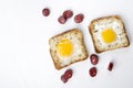 Top view of two eggs in the baskets and tasty fried pieces of sausages on the white background.Traditional breakfast