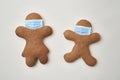 Top view of two gingerbread man with face masks Royalty Free Stock Photo