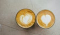 Top view of two glasses of coffee with art hearts on foam on marble background. Royalty Free Stock Photo