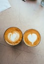 Top view of two glasses of coffee with art hearts on foam on marble background. Royalty Free Stock Photo