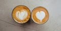 Top view of two glasses of coffee with art hearts on foam on marble background. Royalty Free Stock Photo