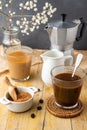 Top view of two glasses with iced coffee, coffee beans, brown sugar, milk jug with coffee pot and white flowers, with selective fo Royalty Free Stock Photo