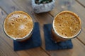Top view of two glasses of iced cold frappes on a wooden table Royalty Free Stock Photo