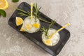 Top view of two glasses of sparkling water with lemon and ice cubes on a ceramic tray and concrete table. fruit water is a concept Royalty Free Stock Photo