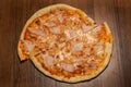 top view on two halfs of pizza with ham and pineapple pieces