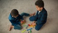 Top view two little siblings boys African American friends kids schoolboys children play game sit on carpet in living Royalty Free Stock Photo