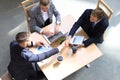 Top view of two men sitting at the desk and shaking hands while young woman looking at them and smiling. Royalty Free Stock Photo