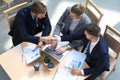 Top view of two men sitting at the desk and shaking hands while young woman looking at them and smiling. Royalty Free Stock Photo