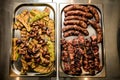 Top view of two metal trays with grilled meat, sausages, vegetables and mushrooms Royalty Free Stock Photo